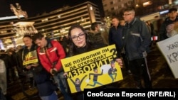 Протестираща срещу връщането на хартиените бюлетини и другите промени в Изборния кодекс, гласувани от ГЕРБ, ДПС и БСП. Снимката е от 18 ноември