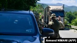 NATO soldiers greet a truck driver near the town of Zubin Potok on August 1. 