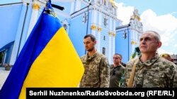 Soldați ucraineni care participă la funeraliile unui coleg ucis pe front, 18 iulie 2022.