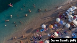 Turisti uživaju na plaži, u Dubrovniku, Hrvatska, petak, 13. kolovoza 2021. Ljetni turizam je ove godine premašio i najoptimističnija očekivanja u Hrvatskoj. Plaže duž obale Jadranskog mora prepune su ljudi. 