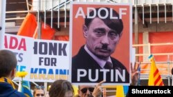 Vlagyimir Putyint Adolf Hitlerhez hasonlító transzparens egy torontói tüntetésen 2022. március 6-án