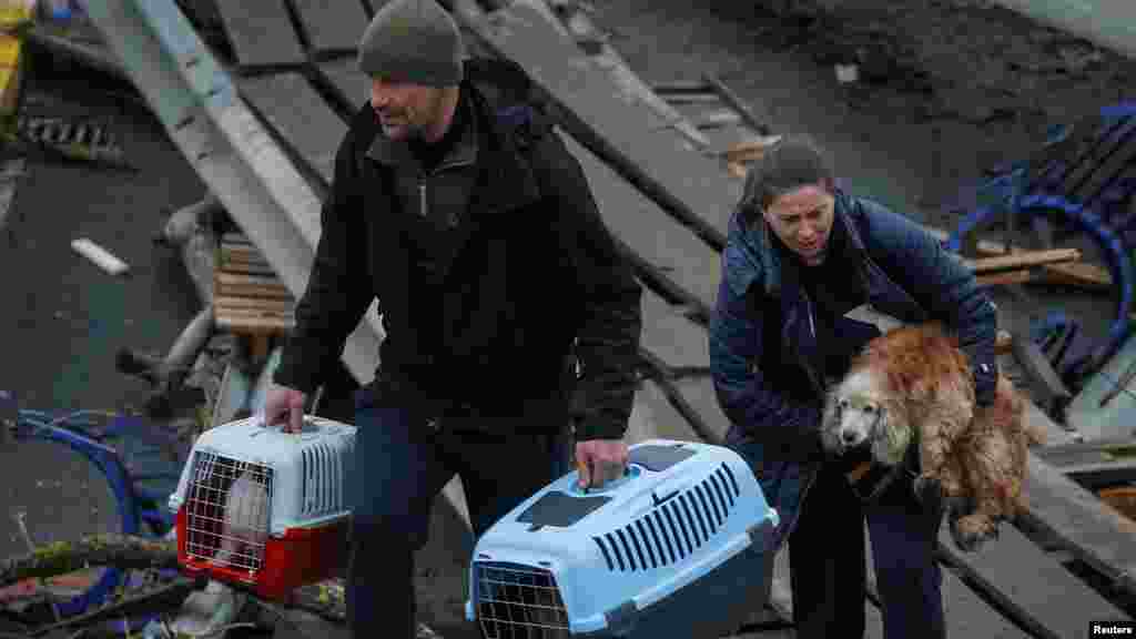 Egy nő a kutyáját cipeli a Kijev melletti Irpiny városában az ukrajnai orosz invázió előli evakuálás közben, 2022 áprilisában