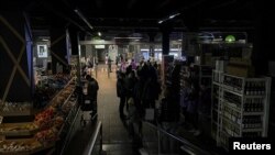Ljudi u supermarketu u Kijevu tokom nestanka struje 22. oktobra 2022. 