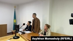 Подсудимый по делу о гибели пастуха во время Январских событий в Талдыкоргане Марк Злуняев. Слева от него его мать Татьяна Злуняева, справа — адвокат Гульнара Валимова. 20 октября 2022 года