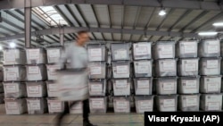 Një punëtor shihet duke bartur kutitë e mbushura me vota në Qendrën e Numërimit dhe Rezultateve. Fotografi nga arkivi.