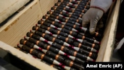 Боснійський робітник складає порожні боєприпаси в ящик