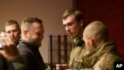 Міністр внутрішніх справ України Денис Монастирський розмовляє із командиром полку «Азов» Денисом Прокопенком та іншими звільненими із російського полону в результаті обміну полоненими. Кінець доби 21 вересня 2022 року
