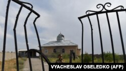 A Kyrgyz soldier patrols near a damaged mosque in the village of Maksat near the Kyrgyz-Tajik border after deadly clashes broke out in the region earlier this month. 