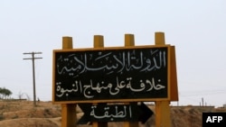 FILE: An Islamic State group banner showing an arrow towards the town of Tabqa in Syria.