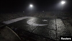 Students stand together to form the world's largest human flag to qualify for the Guinness World Records at the National Hockey Stadium in Lahore on October 22.