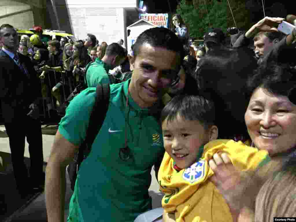 Кыргызстандын дарбазасына 50-мүнөттө экинчи голду киргизген австралиялыктардын коргоочусу Тим Кехил менен оюнду көрүүгө келгендер менен сүрөткө түшүүдө.