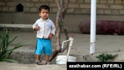 Suw gabynyň golaýynda duran çaga.