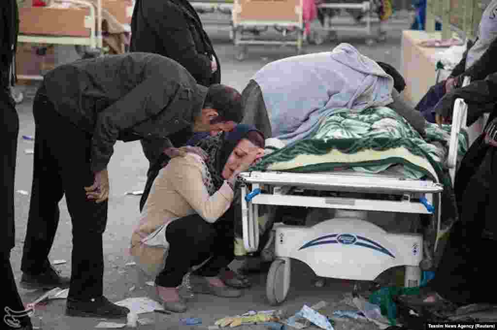 A woman mourns next to a body in Sarpol-e Zahab.