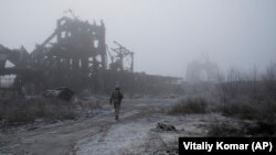 Український солдат іде крізь туманповз зруйновану вугільну шахту, наближаючись до лінії фронту в Авдіївці, 19 листопада