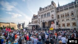 Ґерґей Карачонь (видно на екранах) виступає на демонстрації перед будівлею парламенту Угорщини в Будапешті проти суперечливого проєкту китайського університету, 5 червня 2021 року