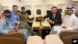 Cetățeanul american Amir Amiri (stânga) stă lângă o femeie neidentificată la bordul unui avion în Kabul. Cu el (de la dreapta) sunt un diplomat din Qatar, asistentul adjunct al președintelui SUA, Sebastian Gorka, și trimisul special al SUA, Adam Boehler.