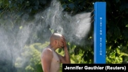  В Ванкувере жители охлаждаются как умеют - в том числе и с помощью специальных опрыскивателей. Канада. 27 июня 2021 года