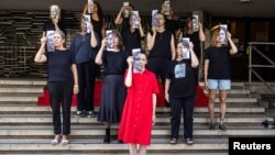 خانواده‌ها و حامیان گروگان‌ها با عکس آنها در تل‌آویو 