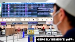 Maszkot viselő utas a budapesti Liszt Ferenc Nemzetközi Repülőtéren 2020. március 23-án