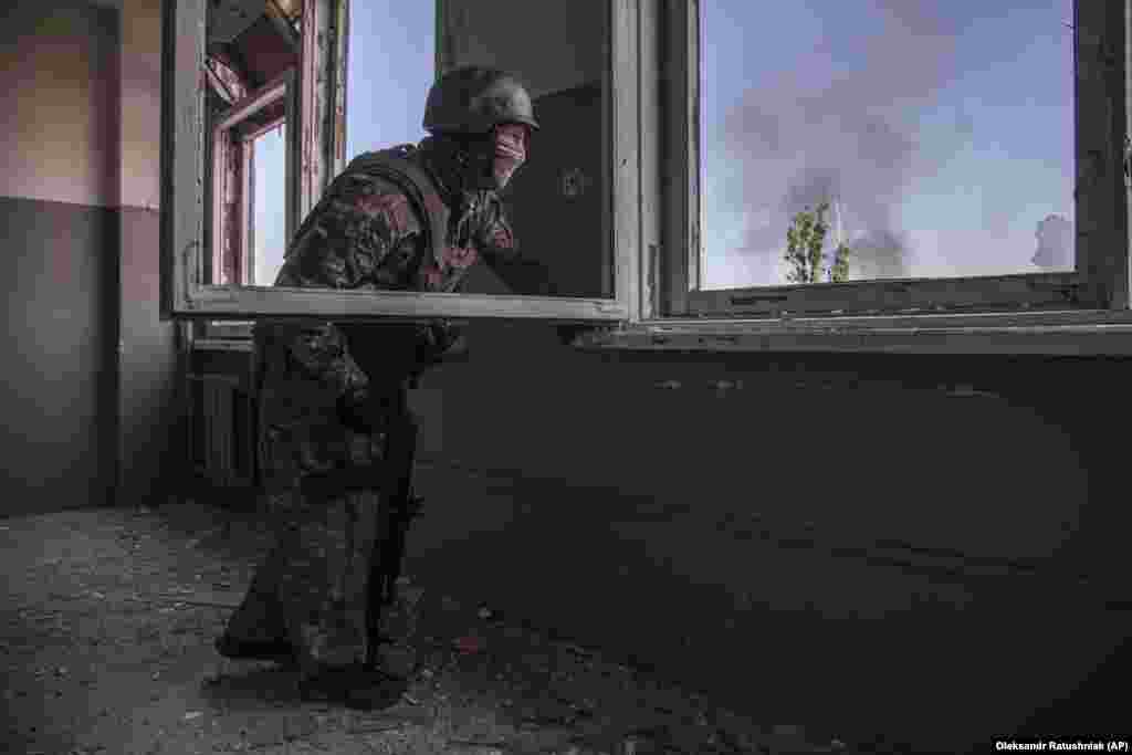 Украински војник ја гледа битката што се одвива под него во градот Северодоњецк.