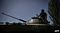 Украински войник стои върху брониран автомобил, движещ се към линията на фронта в град Лисичанск в района на Донбас в Източна Украйна на 9 юни 2022 г.