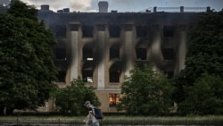 Un bărbat merge prin fața unui liceu din Lîsîceansk (Foto AFP)