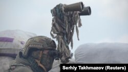 Un militar ucrainean urmărește mișcările din preajma liniei de demarcației lângă orașul Donețk, 6 aprilie, 2021.