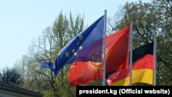 Европа биримдигинин, Кыргызстандын жана Германиянын желектери. 2017-жылы ошол кездеги кыргыз президент Сооронбай Жээнбековдун Берлинге сапары учурунда тартылган. 