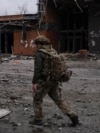 Український військовослужбовець проходить повз будівлю, пошкоджену російськими військовими ударами, в місті Покровськ Донецької області