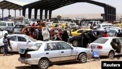 Families fleeing the violence in the city of Mosul arrive at a checkpoint on the outskirts of Irbil in the Kurdistan region on June 10.