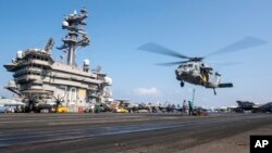 نمایی از پرواز یک بالگرد بر روی عرشه ناو یواس‌اس کارل وینسون