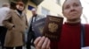 Окупований Крим. Жінка тримає український і російський паспорти біля офісу Федеральної міграційної служби Росії, де вона отримала російський паспорт від окупаційної влади. Сімферополь 7 квітня 2014 року