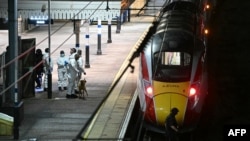 Сотрудники полиции проходят по платформе на станции Хантингдон рядом с поездом, в котором произошла ножевая атака, Великобритания, 1 ноября 2025 года