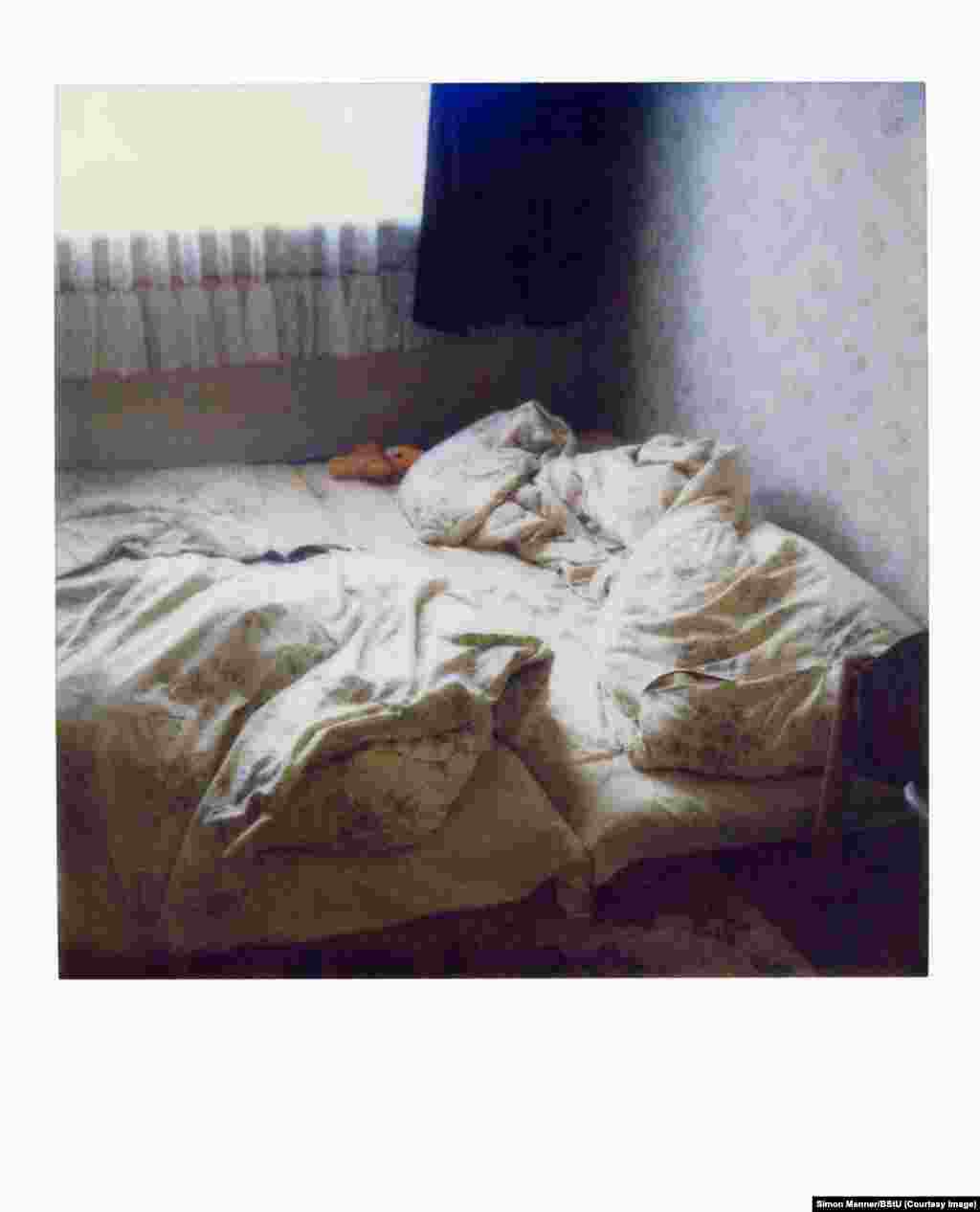 Fotografie polaroid a unui pat într-un apartament. Aceste fotografii făcute la perchezițiile secrete&nbsp;îi ajutau pe agenții STASI&nbsp;să pună la timp lucrurile la locul lor înainte de întoarcerea acasă a proprietarului, care nu trebuia să afle că i-a fost percheziționat apartamentul.