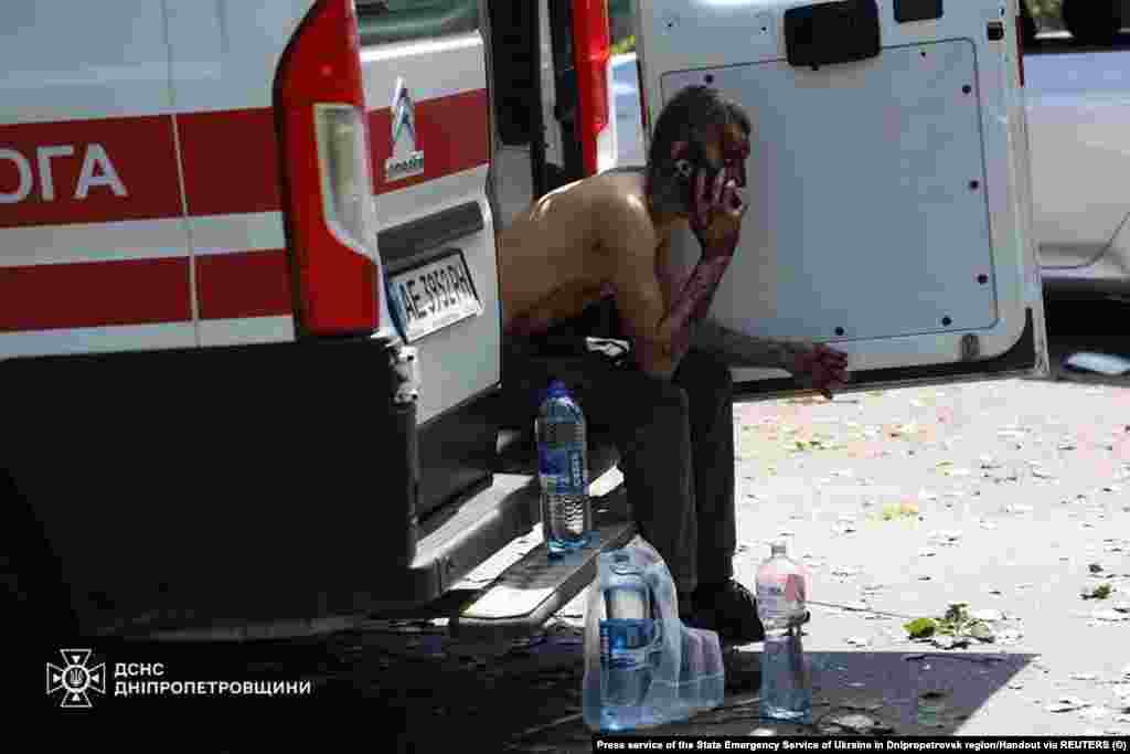 Чоловік, якого поранило під час російського ракетного удару, розмовляє по телефону, сидячи в машині швидкої допомоги, Дніпропетровська область, 24 червня 2025 року.Через атаку РФ у регіоні загалом постраждали майже 300 людей