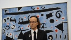 Внукът на Миро - Жоан Пуниет Миро позира пред картината на своя дядо "Хора и птици танцуват на синьо небе; Искри"