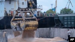 Работници товарят зърно на пристанище за зърно в Измаил, Украйна, на 26 април 2023 г.