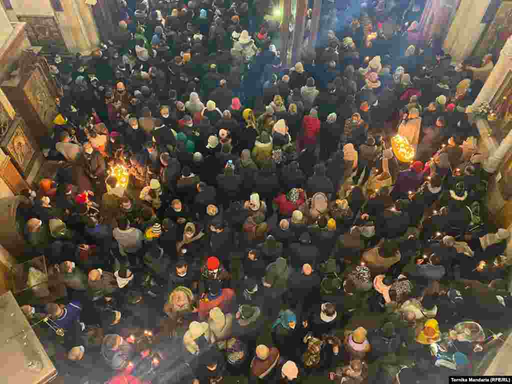 Credincioși participând la slujba de Crăciun care are loc în catedrala Sfânta Treime din Tbilisi.
