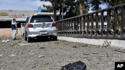A man takes pictures at the site of a car bomb blast on an intelligence compound in Aybak, the capital of the Samangan Province on July 13.