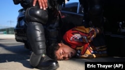 Задержание протестующего сотрудниками дорожным патрулем Калифорнии возле федерального здания в центре Лос-Анджелеса, 10 июня 2025 года. Фото AP