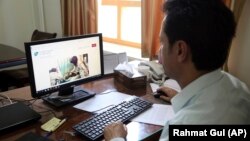 Ahmad Khalid Fahim, program director for the Swedish Committee for Afghanistan shows the group's website during an interview with The Associated Press in Kabul on July 17.