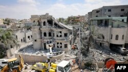 Спасательные команды расчищают завалы в районе поселения Тамра на севере Израиля после ночного ракетного обстрела со стороны Ирана, 15 июня 2025 года