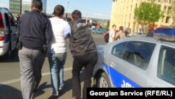 პოლიცია აკავებს აქციის მონაწილეს. თბილისი, 2013 წლის 1 მაისი 