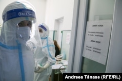 În combinezoane și echipați cu măști și mânuși, medicii merg la fiecare pacient în parte.