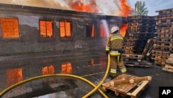 Un pompier lucrează la stingerea unui incendiu provocat de atacurile rusești asupra regiunii Kievului.