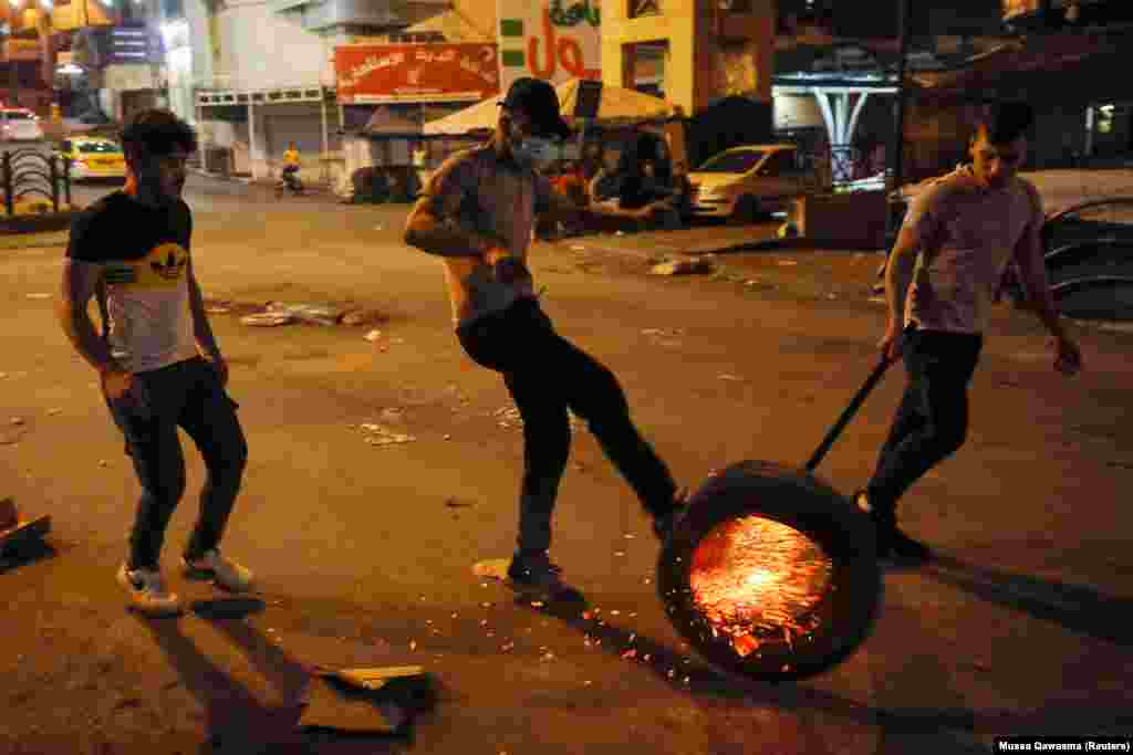 Egy égő gumiabroncsot gurítanak végig az utcán Hebron városában. Az indulatokat a Ramadán ünnep alatti korlátozások váltották ki.