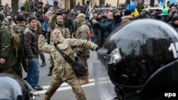 Мітингувальник кидає камінь у відділення «Сбербанку Росії», Київ, 20 лютого 2016 року