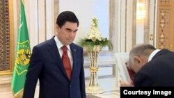 Церемония вручения книг президента  правительственным чиновникам. Президент Туркменистана Г.Бердымухамедов (слева)  