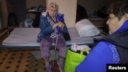 13-nji oktýabrda giçlik Russiýanyň Harkow şäherine eden howa hüjümi wagtynda hassalar ýerzeminde pena gözleýärler. 