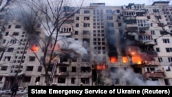 Спасатели работают возле жилого дома, поврежденного в результате обстрела Киева, 14 марта 2022 года